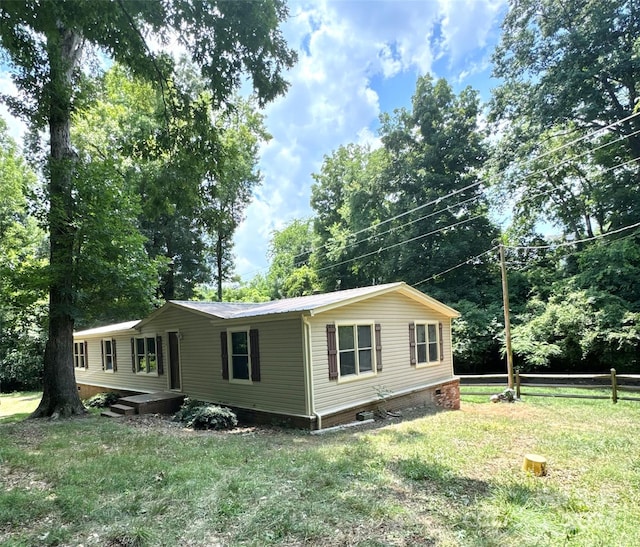 view of side of home with a yard