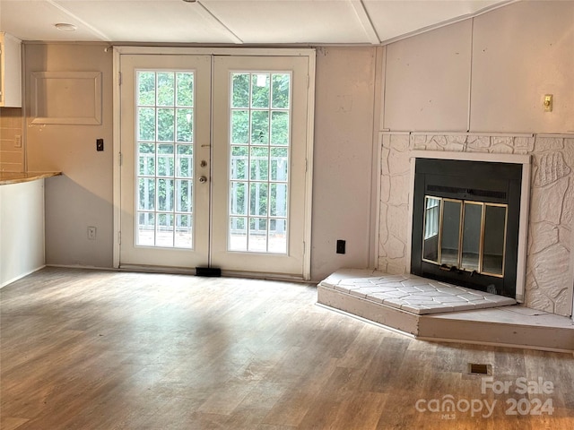 entryway featuring hardwood / wood-style flooring, a fireplace, and french doors