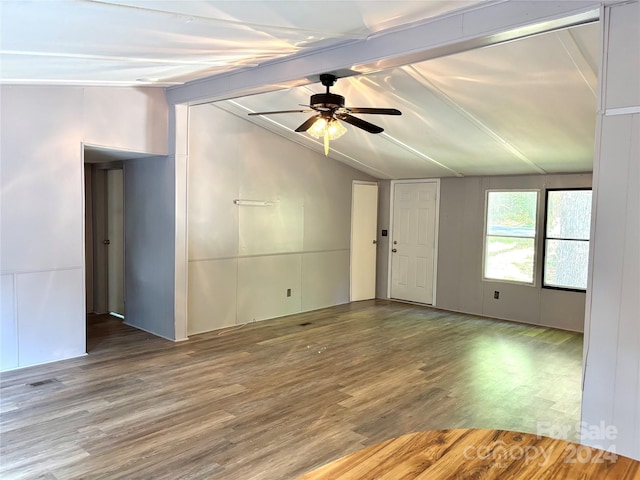 unfurnished room with vaulted ceiling with beams, ceiling fan, and hardwood / wood-style flooring