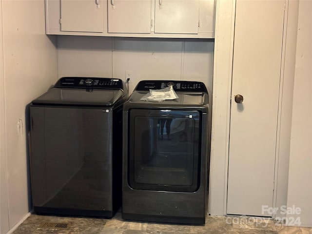 laundry room with cabinets and washer and dryer