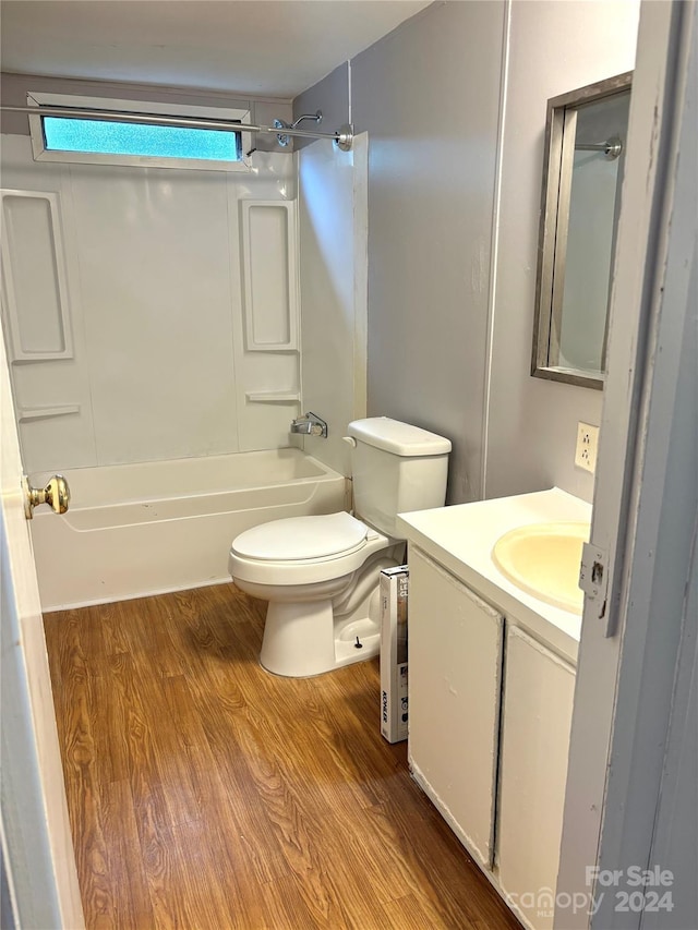 full bathroom featuring hardwood / wood-style floors, vanity, shower / bathtub combination, and toilet