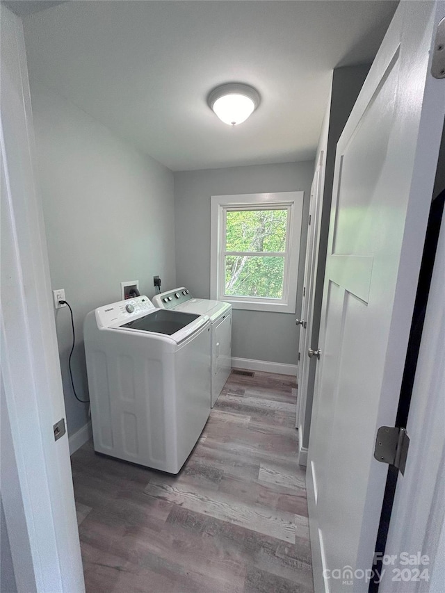 clothes washing area featuring light hardwood / wood-style flooring and independent washer and dryer