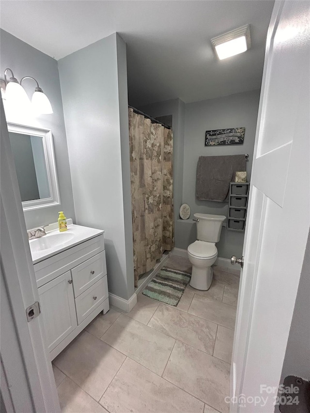 bathroom with toilet, a shower with shower curtain, tile patterned floors, and vanity