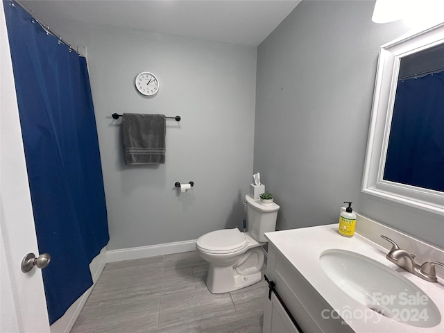 bathroom featuring toilet, vanity, and walk in shower