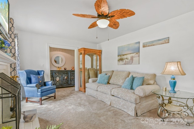 carpeted living room with ceiling fan and a fireplace