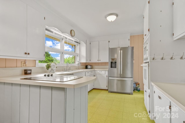 kitchen featuring kitchen peninsula, sink, white appliances, and white cabinetry