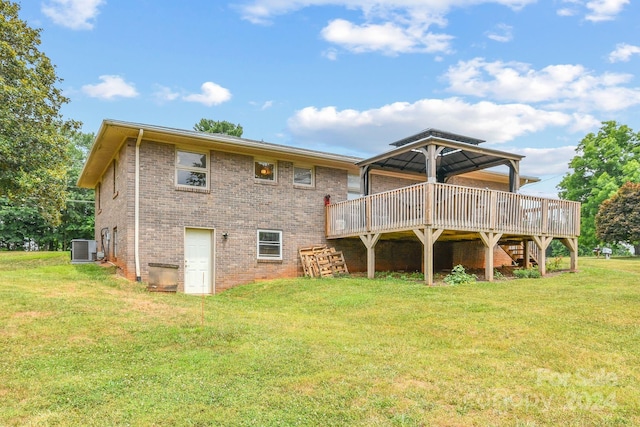 rear view of property featuring central AC unit, a gazebo, a deck, and a yard