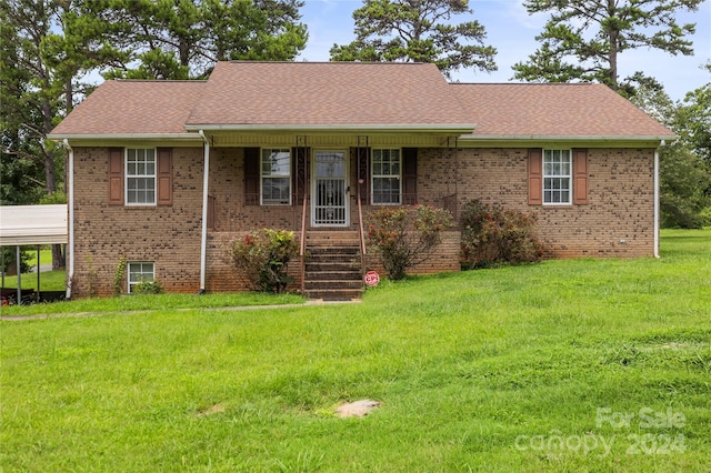 ranch-style home with a shingled roof, brick siding, and a front lawn