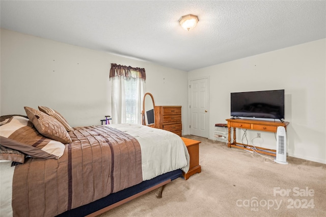 bedroom featuring a textured ceiling and light colored carpet