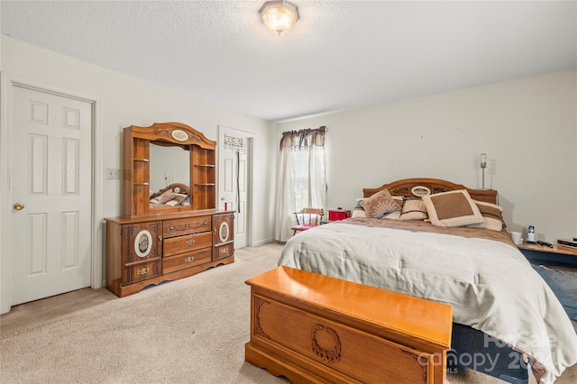 bedroom featuring light carpet and a textured ceiling