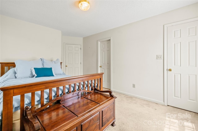 bedroom with light colored carpet and a textured ceiling