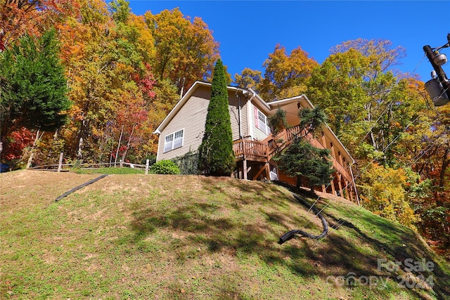 view of home's exterior with a wooden deck and a yard