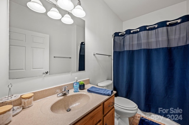 bathroom with curtained shower, vanity, and toilet