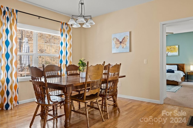 dining space with a notable chandelier and light hardwood / wood-style flooring