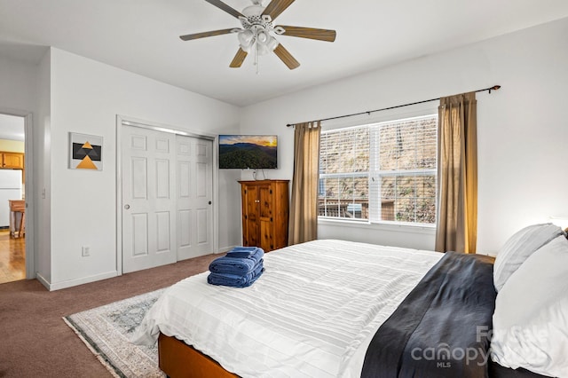 bedroom with ceiling fan, carpet flooring, a closet, and white fridge