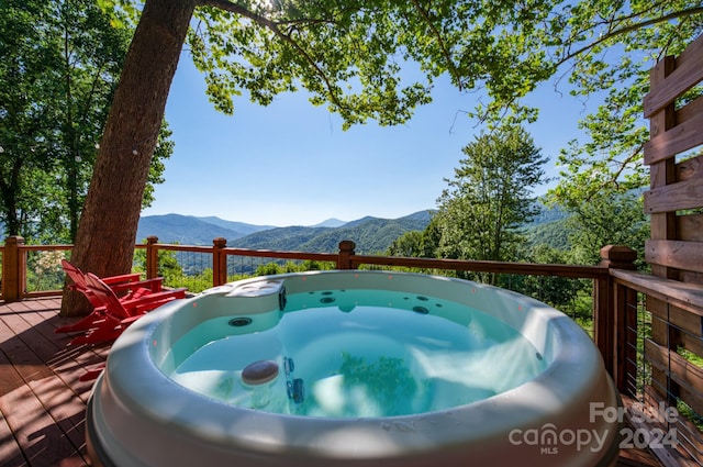 wooden deck with a mountain view and a hot tub