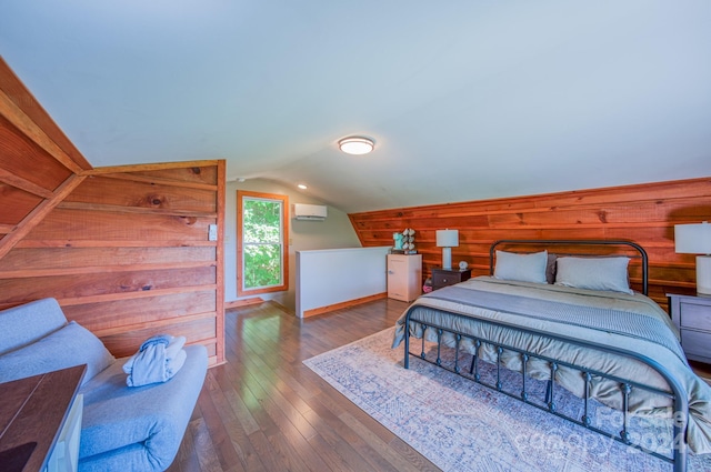 bedroom with a wall unit AC, lofted ceiling, hardwood / wood-style flooring, and wooden walls