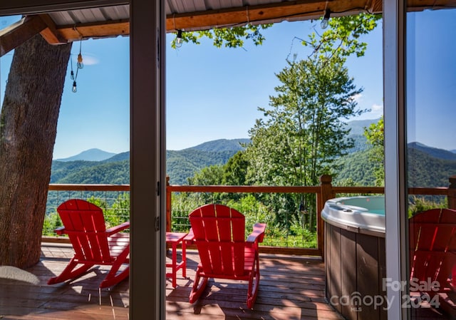 deck with a mountain view and a hot tub