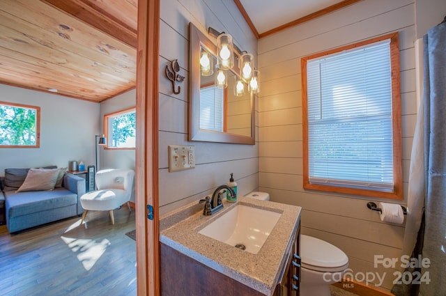 bathroom with hardwood / wood-style floors, vanity, wood walls, wooden ceiling, and crown molding