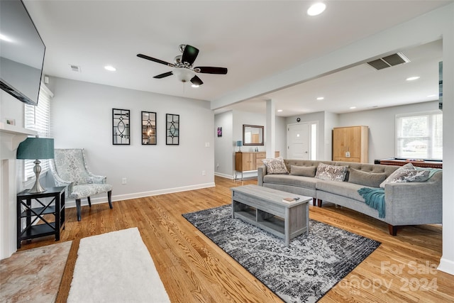 living room featuring wood-type flooring and ceiling fan