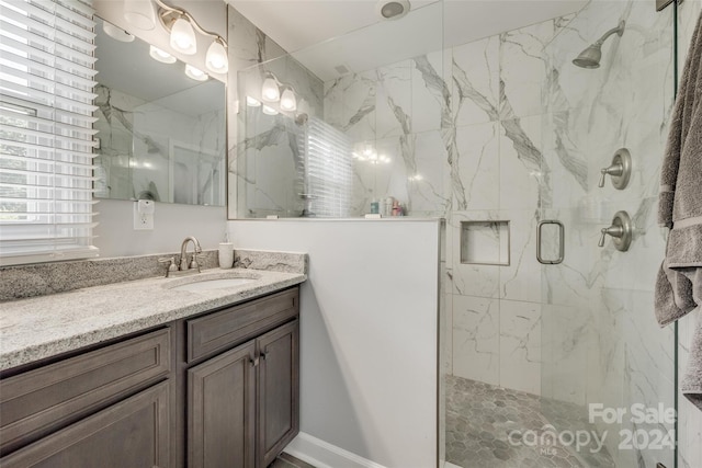 bathroom featuring vanity and a shower with door