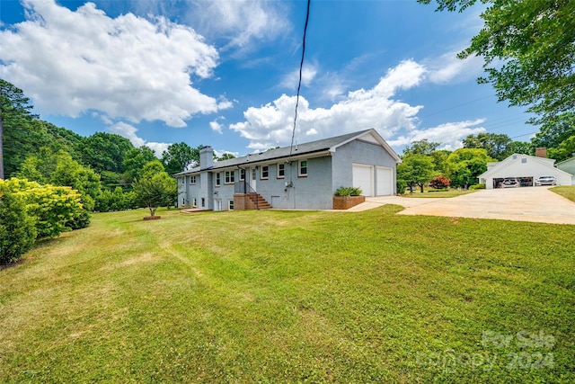 back of property with a lawn and a garage