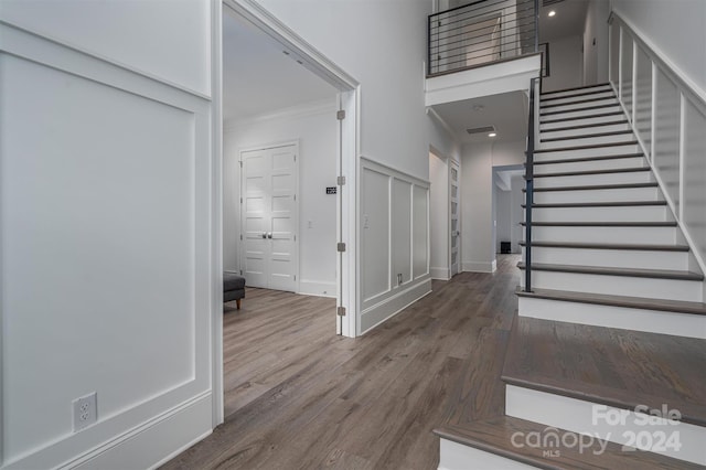 entrance foyer featuring crown molding and wood-type flooring