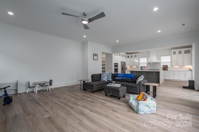 living room featuring ornamental molding, ceiling fan, and light hardwood / wood-style floors