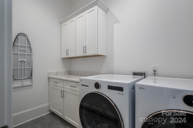 washroom featuring washer and clothes dryer, cabinets, and dark tile patterned floors