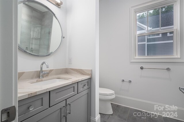 bathroom featuring vanity, toilet, and tile patterned flooring