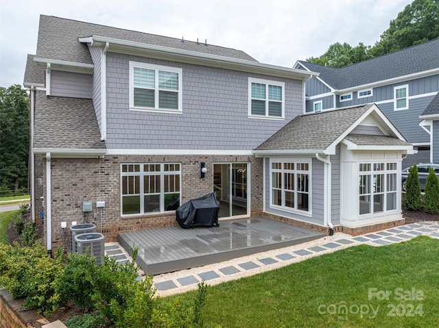 rear view of house with central AC unit, a yard, and a patio area