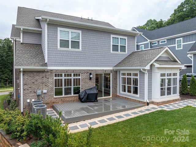 rear view of property featuring a yard, central AC, and a deck