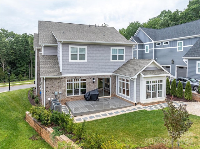 back of property with a wooden deck, a yard, and a patio