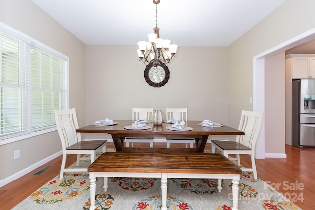 dining area with hardwood / wood-style floors and a chandelier