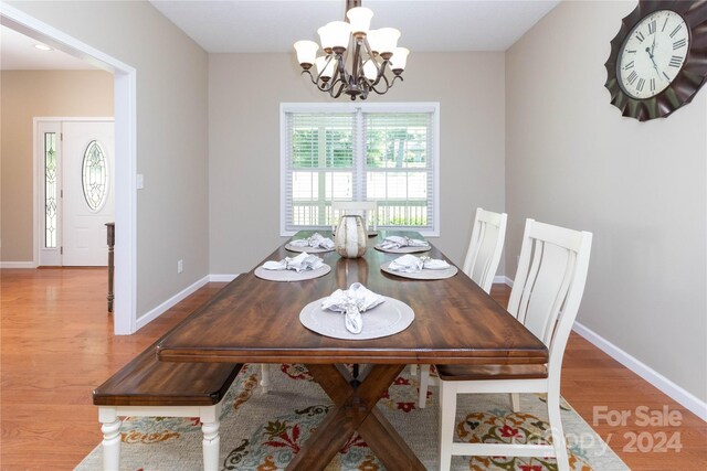 dining space featuring hardwood / wood-style flooring and a notable chandelier