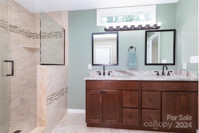 bathroom featuring tile patterned floors, vanity, and a shower with door