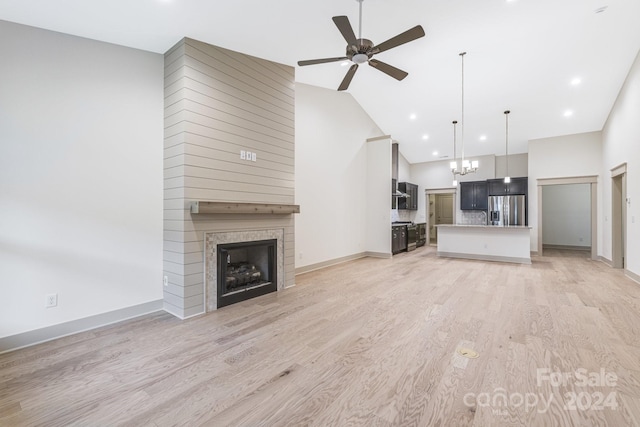 unfurnished living room with a fireplace, light hardwood / wood-style floors, high vaulted ceiling, and ceiling fan