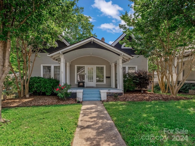 entrance to property with a lawn and covered porch