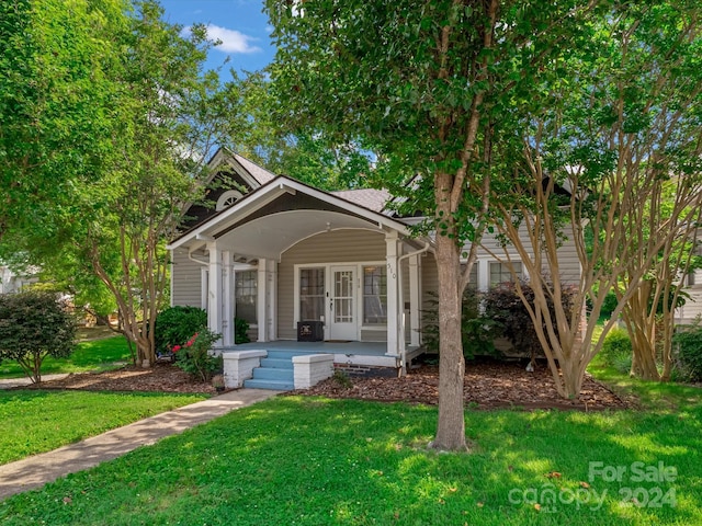 bungalow-style home with covered porch and a front yard