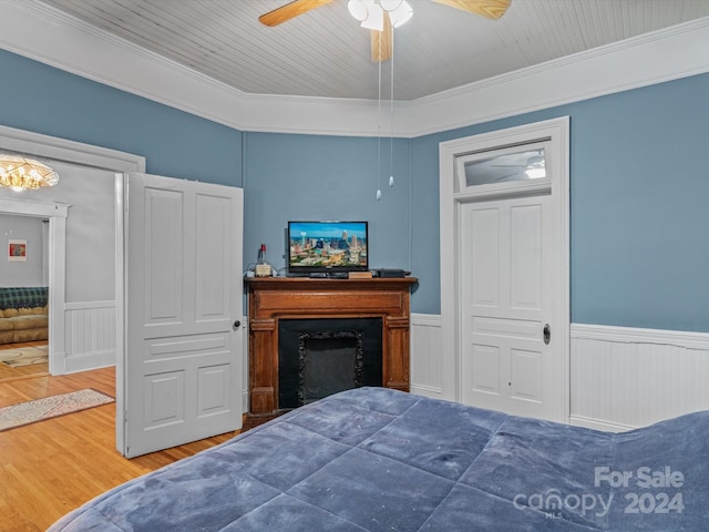 bedroom with hardwood / wood-style flooring, ceiling fan, and crown molding