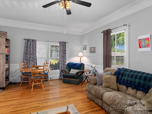 living room with ceiling fan, ornamental molding, a wealth of natural light, and light hardwood / wood-style flooring