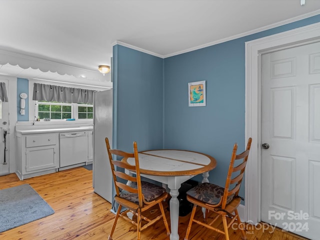 dining room featuring light hardwood / wood-style floors, ornamental molding, and sink