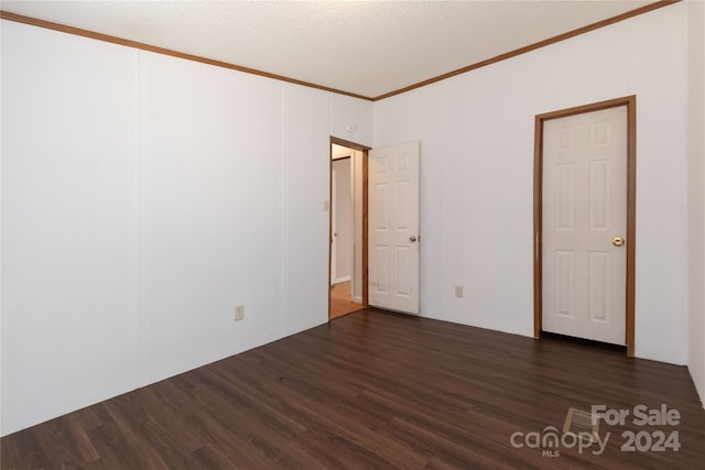 unfurnished room with ornamental molding, dark hardwood / wood-style flooring, and a textured ceiling