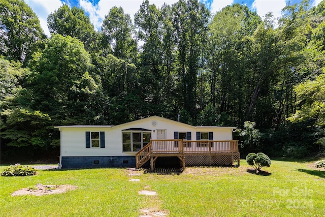 rear view of property featuring a wooden deck and a yard