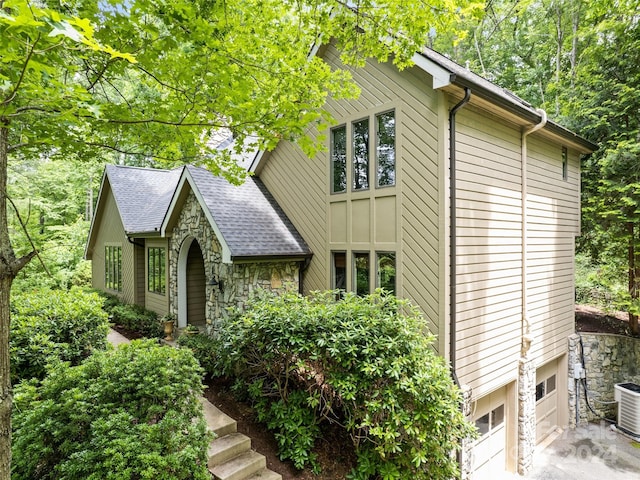 view of property exterior with central AC and a garage