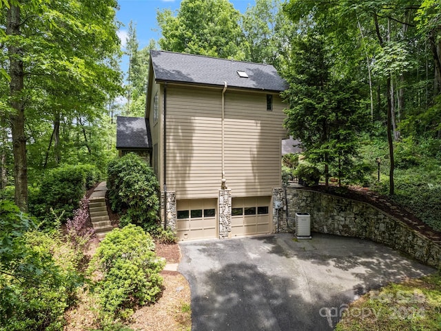 view of side of property with central AC unit and a garage