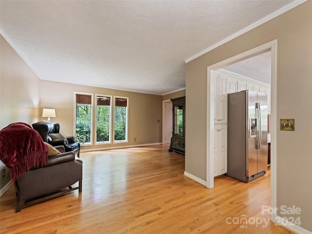 living room with a textured ceiling, light hardwood / wood-style flooring, and ornamental molding