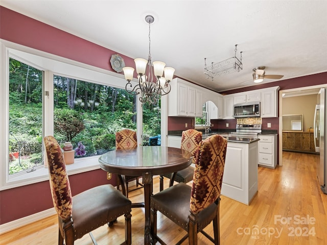 dining room with light hardwood / wood-style flooring, ceiling fan with notable chandelier, and sink