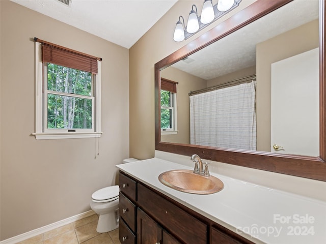 bathroom with walk in shower, tile patterned flooring, vanity, and toilet