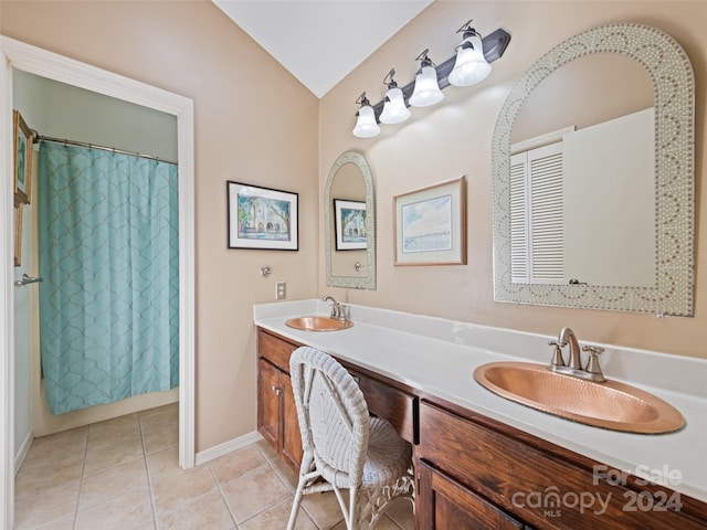 bathroom featuring tile patterned flooring, vanity, and lofted ceiling